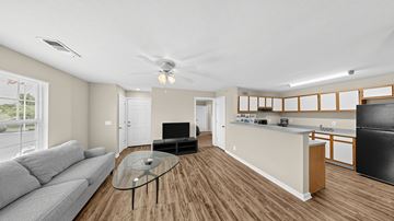 Omaha apartment for rent - A living room with a grey couch and a glass coffee table.