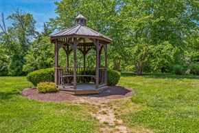 Louisville apartment for rent - A gazebo is surrounded by a grassy area and trees.
