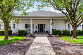 Springfield apartment for rent - the front of a white house with trees and a flag