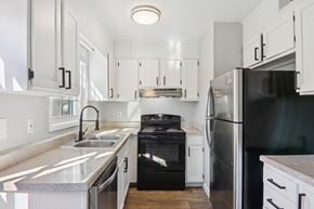 Spartanburg apartment for rent - A modern kitchen with a black stove top oven and a black refrigerator.