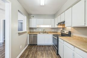 Augusta apartment for rent - A kitchen with white cabinets and a wooden counter top.