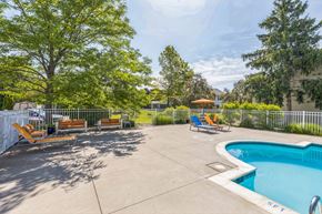 Canton apartment for rent - Pool area with loungers at Bainbridge Park Canton MI