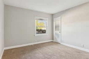 Spartanburg apartment for rent - A room with a carpeted floor and a window showing trees outside.