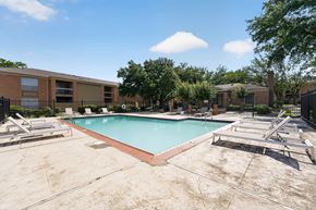 Jackson apartment for rent - A swimming pool surrounded by a concrete floor and lounge chairs.