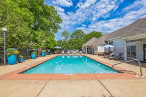 Prattville apartment for rent - A swimming pool surrounded by trees and a house.