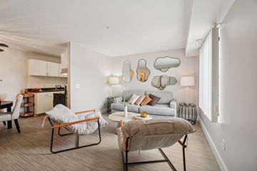 Canton apartment for rent - A modern living room with a grey sofa, a chair and a table.