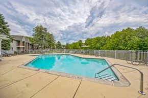 Westland apartment for rent - A large swimming pool surrounded by a metal fence and trees.