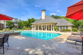 Macon apartment for rent - a swimming pool with chairs and umbrellas in front of a house