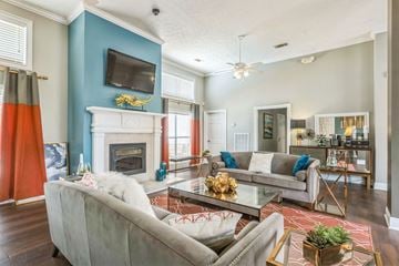 Prattville apartment for rent - A living room with a grey couch and a fireplace.