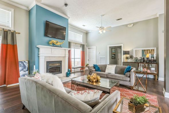 Prattville apartment for rent - A living room with a grey couch and a fireplace.