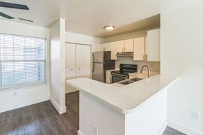 Port Huron apartment for rent - A kitchen with white countertops and a window with blinds.