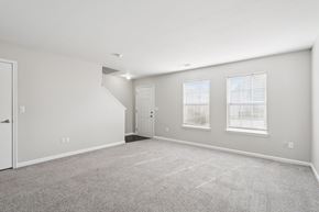 West Des Moines apartment for rent - A spacious room with a carpeted floor and a staircase leading to another room.