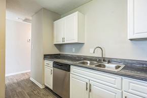 Prattville apartment for rent - A kitchen with white cabinets and a black countertop.