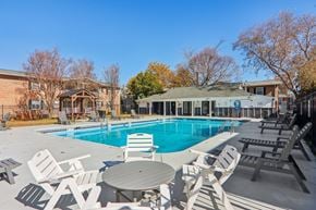 Spartanburg apartment for rent - A pool surrounded by chairs and tables.