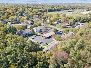 Parchment apartment for rent - An aerial view of a residential area with houses and trees.