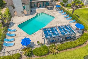 Mobile apartment for rent - A large swimming pool surrounded by sun loungers and umbrellas.