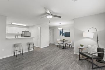 Independence apartment for rent - A living room with a grey sofa and a dining table with chairs.