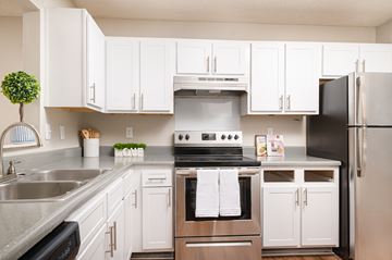 Richland apartment for rent - A modern kitchen with white cabinets and stainless steel appliances.