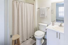Port Huron apartment for rent - A white toilet sits next to a white sink in a bathroom.