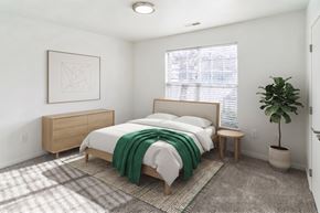 Port Huron apartment for rent - A bedroom with a bed, nightstand, and a potted plant.