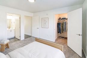 Port Huron apartment for rent - A bedroom with a bed, a wardrobe, and a vanity.