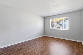 Tallahassee apartment for rent - A room with wooden flooring and a window showing a building outside.