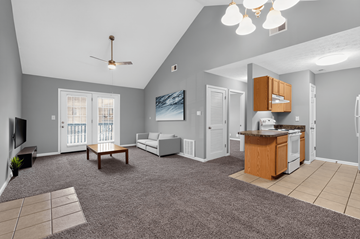 Shelbyville apartment for rent - A spacious living room with a grey carpet and a ceiling fan.