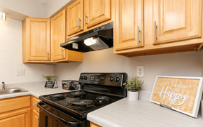 Louisville apartment for rent - A kitchen with wooden cabinets and a black stove top oven.