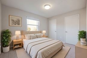 Richmond apartment for rent - A bedroom with a large bed and two potted plants.