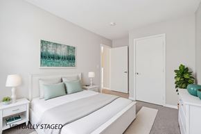 West Des Moines apartment for rent - A bedroom with a large bed, two lamps, and a painting on the wall.