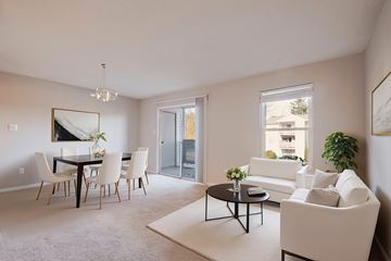 Richmond apartment for rent - A living room with a white couch, a dining table with chairs, and a chandelier.