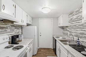 Tallahassee apartment for rent - A kitchen with white cabinets and a white stove top oven.