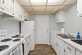 Tallahassee apartment for rent - A kitchen with white cabinets and a white door.