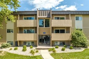 Peoria apartment for rent - A modern building with a central entrance and a gravel area in front.
