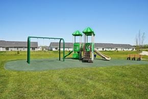 Whitmore Lake apartment for rent - A playground with a green swing set and a green and white slide.