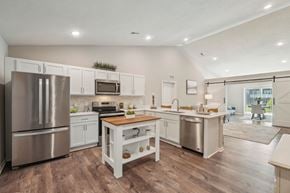 Whitmore Lake apartment for rent - A modern kitchen with a wooden table and stainless steel appliances.