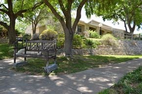 Austin apartment for rent - A playground with a swing set is located in front of a house.