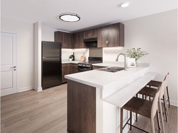 Toledo apartment for rent - A kitchen with a black refrigerator and brown chairs.