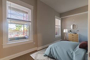 Cincinnati apartment for rent - A bedroom with a bed, nightstand, and window with blinds.
