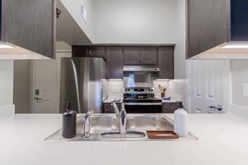 Cincinnati apartment for rent - A modern kitchen with a double sink and a stainless steel refrigerator.