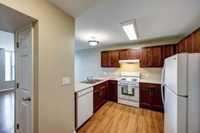 Dublin apartment for rent - Kitchen with cherry cabinets and white appliances at Avondale Senior Village Apartments, Dublin