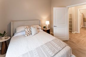 Toledo apartment for rent - A bedroom with a large bed and a small table with a lamp on it.
