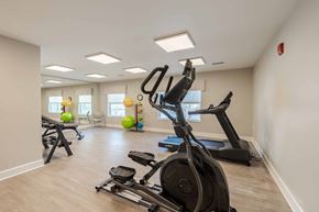 Hebron apartment for rent - A spacious gym with a variety of exercise equipment including treadmills, elliptical machines, and stationary bikes.