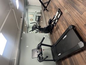 Cincinnati apartment for rent - A treadmill and a stationary bike are in a gym.