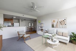 New Port Richey apartment for rent - A living room with a white couch, a chair, a coffee table, and a ceiling fan.