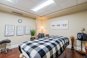 New Port Richey apartment for rent - A massage table covered with a checkered heated blanket and a wall clock.