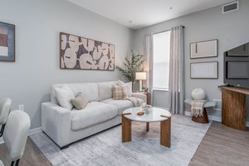 Columbus apartment for rent - A living room with a white couch, a coffee table, and a painting on the wall.