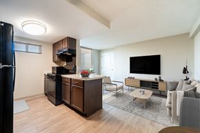 Phoenix apartment for rent - A modern kitchen with dark wood cabinets and a black refrigerator.