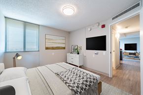 Phoenix apartment for rent - A bedroom with a bed, nightstand, and a painting on the wall.