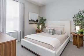 Columbus apartment for rent - A bedroom with a large bed, a wooden nightstand, and a painting on the wall.